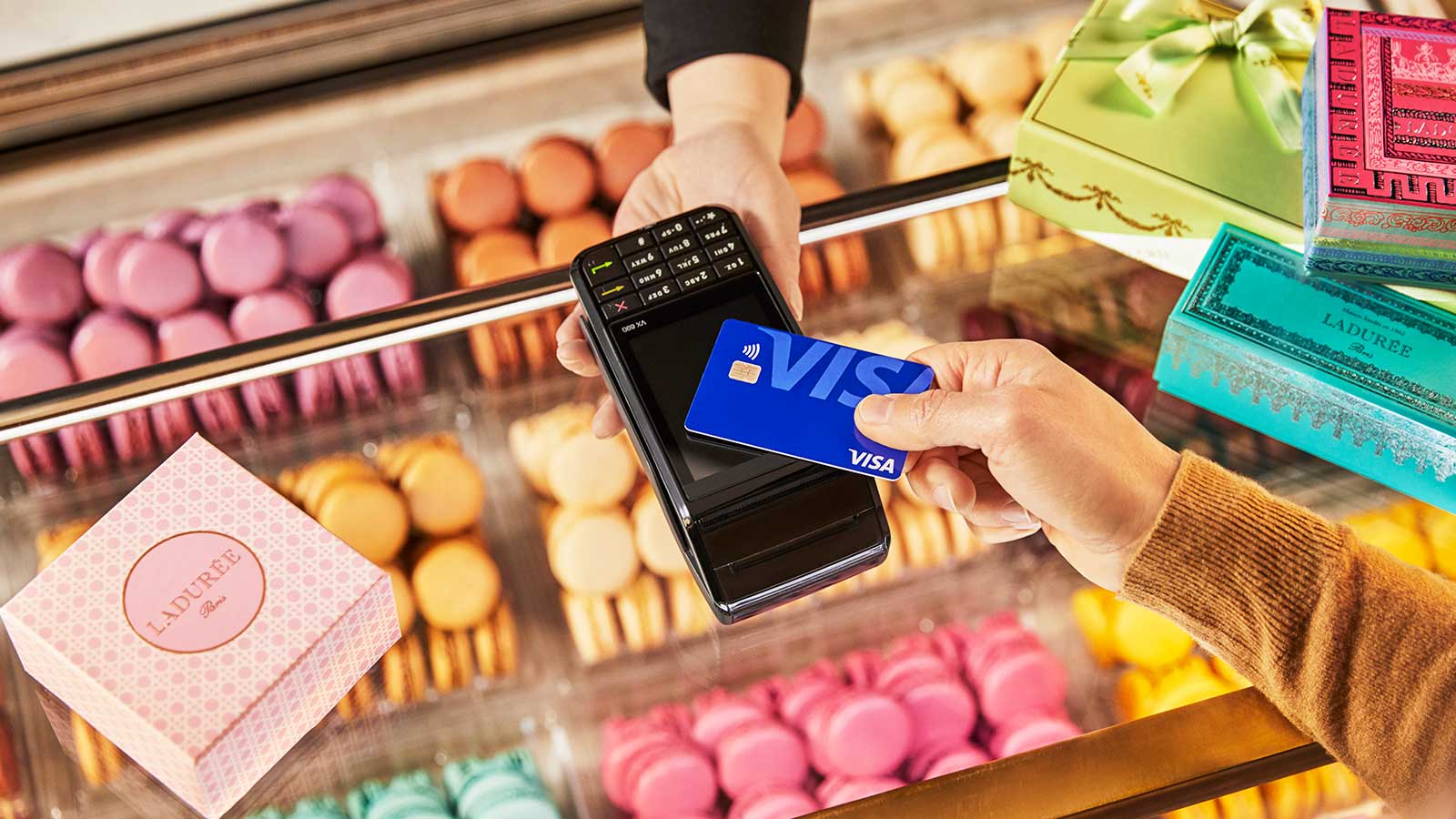 Customer using contactless payment Visa card to purchase baked goods