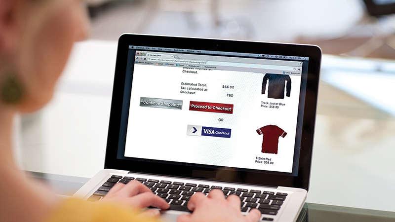 A woman with a laptop doing some online shopping on a website that has Visa Checkout.
