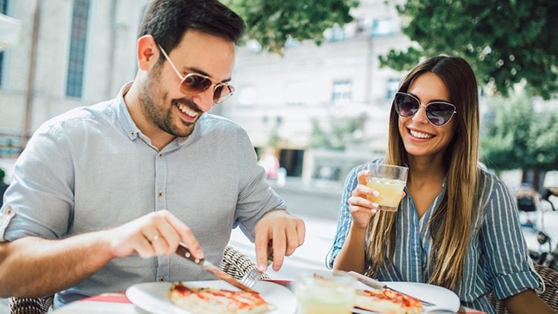 A man and a women dining at a street restaurant